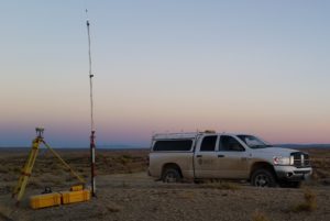 Land surveying equipment next to a WLC truck at sunset